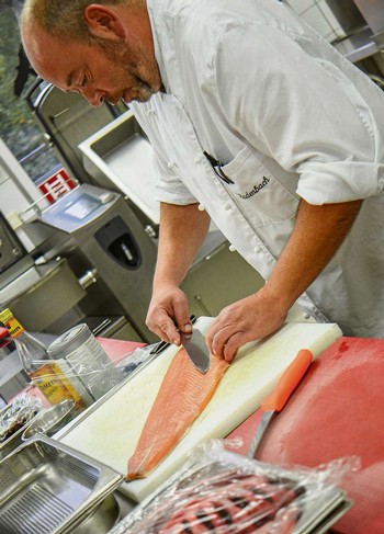 Mit einem Messer streift Hans-Christian Radenbach über das Filetstück, um feine Gräten aufzustellen. Mit einer Pinzette kann er die restlichen Gräten schließlich herausziehen. (WP-Foto: Britta Prasse)