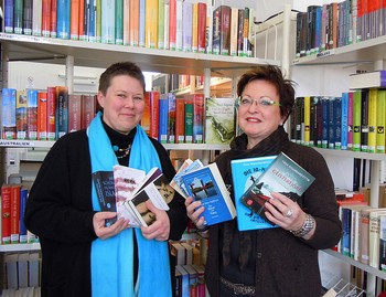 Monika Brandel von der Buchhandlung MankelMuth überreicht die aktuellen Bücher des Literaturpflasters 'Island' an Büchereileiterin Gaby Klotz. (Foto: Rikarde Riedesel)